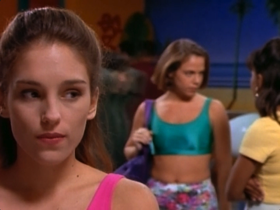 Amy Jo Johnson judges you from the foreground of this shot.